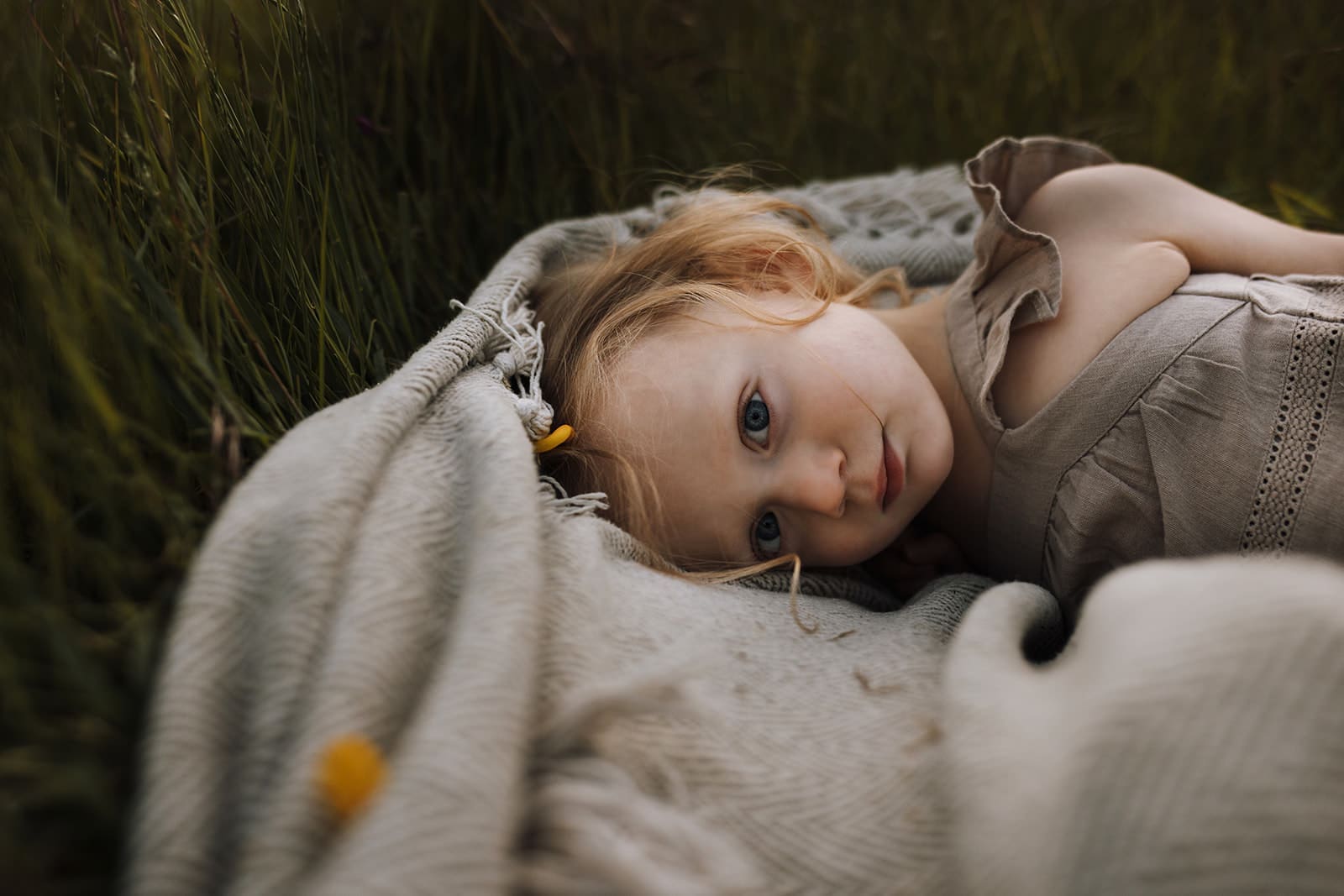 Toddler girl laying on blanket in Victoria, BC