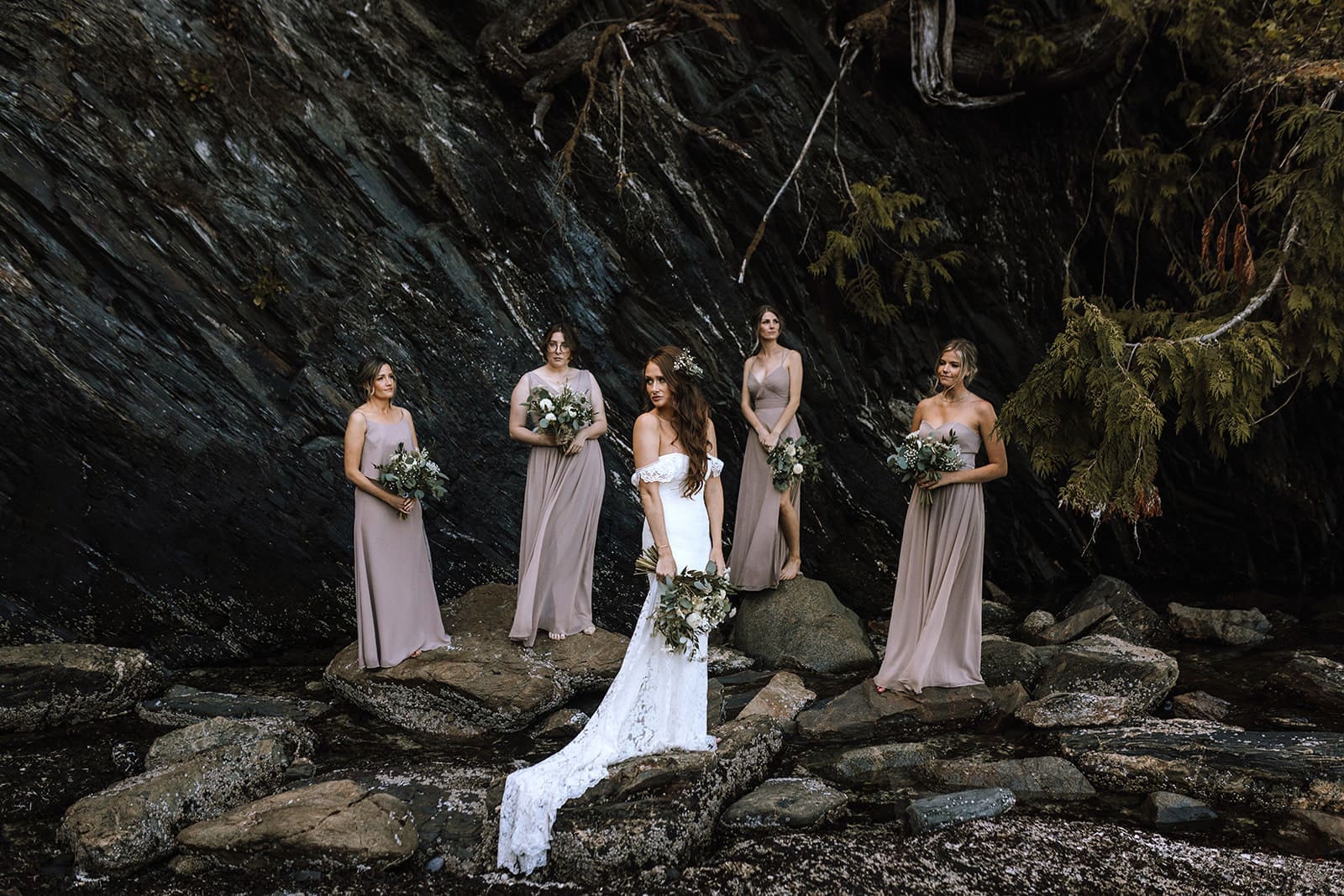 Bridesmaids standing on rocks posing for a photo during a Port Renfrew Wedding
